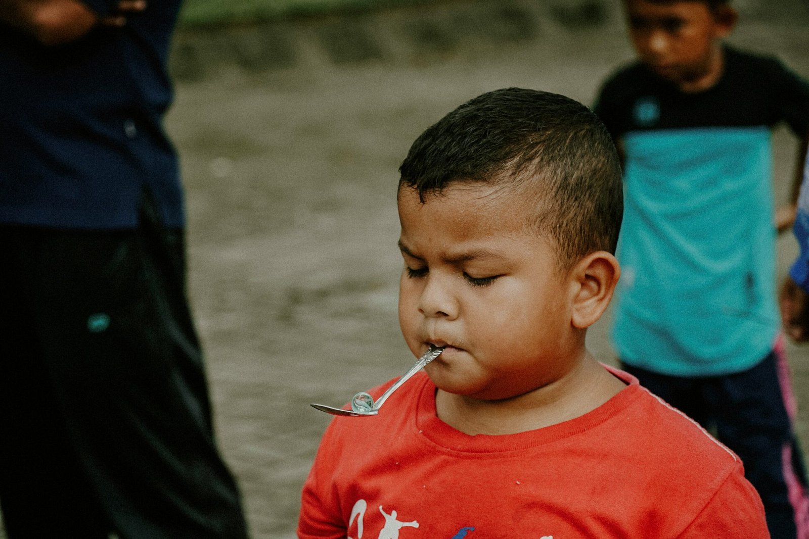 a young boy with a spoon in his mouth