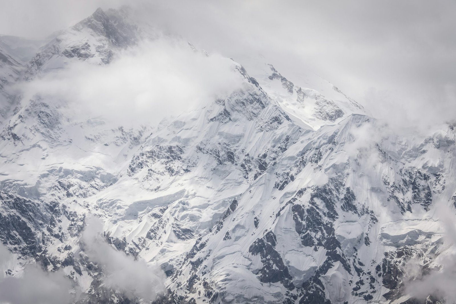 snow covered mountain under cloudy sky during daytime